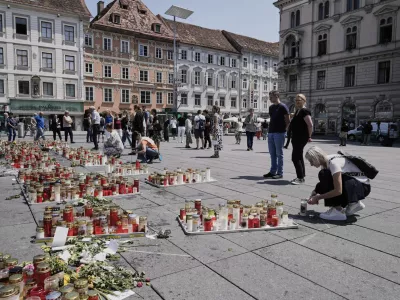 People commemorate the victims of a shooting at a school, where a former student opened fire two days before, at the central square in Graz, Austria, Thursday, June 12, 2025. (AP Photo/Darko Bandic)