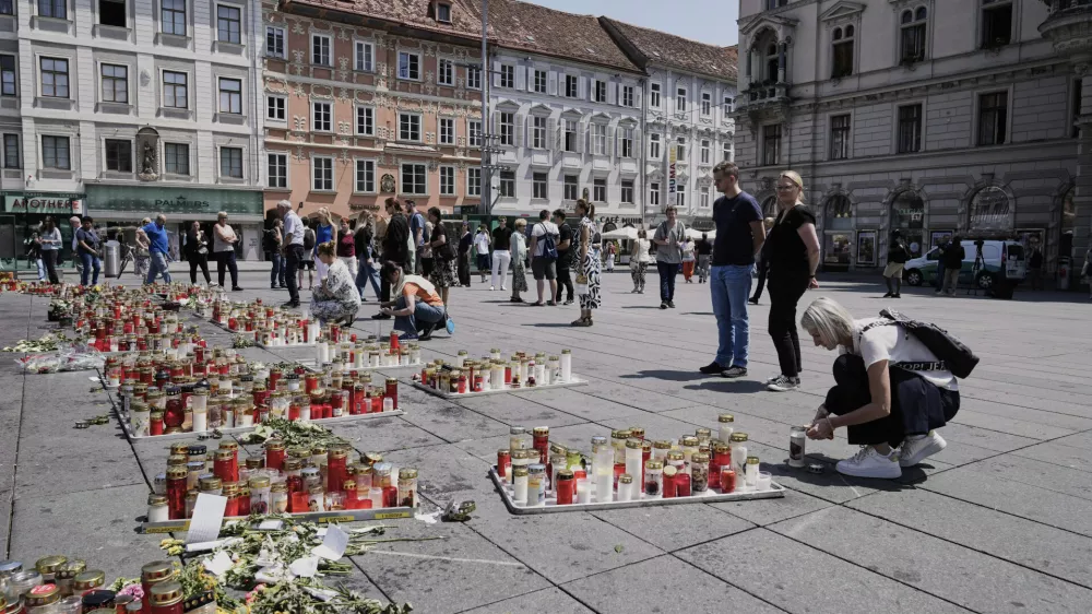 People commemorate the victims of a shooting at a school, where a former student opened fire two days before, at the central square in Graz, Austria, Thursday, June 12, 2025. (AP Photo/Darko Bandic)