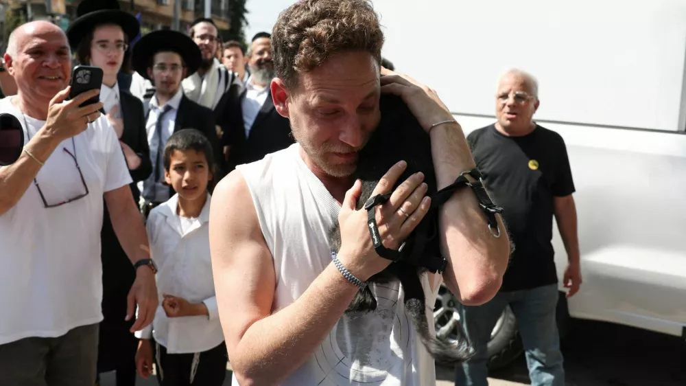 Eli Bachar, 40, reacts as he holds his dog Tess, who was rescued from a building that was hit at an impact site following missile attack from Iran on Israel, in Ramat Gan, Israel, June 14, 2025. REUTERS/Ronen Zvulun
