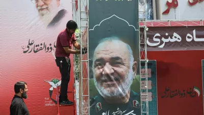A man installs a banner with a picture of late Islamic Revolutionary Guard Corps (IRGC) Commander-in-Chief Major General Hossein Salami, following the Israeli strikes on Iran, in Tehran, June 14, 2025. Majid Asgaripour/WANA (West Asia News Agency) via REUTERS  ATTENTION EDITORS - THIS PICTURE WAS PROVIDED BY A THIRD PARTY.   TPX IMAGES OF THE DAY
