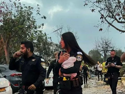 Policistka v rokah drži re&scaron;enega otroka.