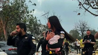 Policistka v rokah drži re&scaron;enega otroka.