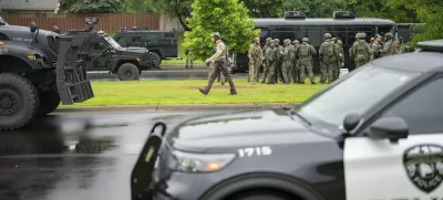 Law enforcement officers including local police, sheriffs and the FBI, stage less than a mile from a shooting in Brooklyn Park, Minn. on Saturday, June 14, 2025. (Alex Kormann/Star Tribune via AP)