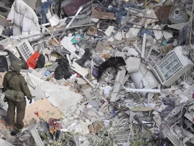 An Israeli military working dog searches rubble for survivors in a residential area hit by a missile fired from Iran, near Tel Aviv, Israel, Sunday, June 15, 2025.(AP Photo/Ariel Schalit)