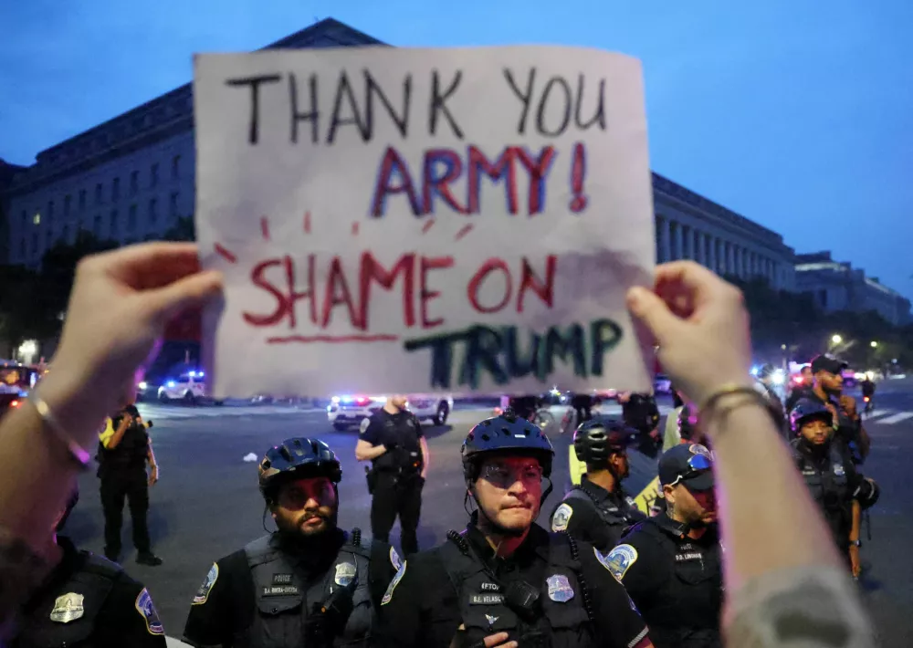 A person holds a sign during a protest on the day of the Army's 250th Birthday Parade in Washington, D.C., U.S., June 14, 2025. REUTERS/Evelyn Hockstein