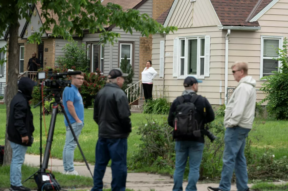 Neighbors look on from their homes as media and others gather outside of a residence associated with 57-year-old Vance Luther Boelter, the suspect in the shooting deaths of senior Democratic state assemblywoman Melissa Hortman and her husband Marc, in Minneapolis, Minnesota, U.S., June 14, 2025.  REUTERS/Tim Evans