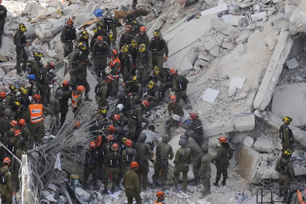 Israeli soldiers search for survivors amid the rubble of residential buildings destroyed by an Iranian missile strike in Bat Yam, central Israel, on Sunday, June 15, 2025. (AP Photo/Baz Ratner)