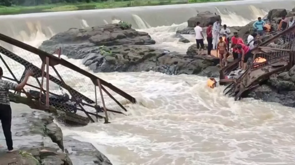Rescue workers and people stand following a bridge collapse over the Indrayani river in the western Indian city, in Pune, India, June 15, 2025, in this still image taken from a video. ANI/Reuters TV via REUTERS  THIS IMAGE HAS BEEN SUPPLIED BY A THIRD PARTY. INDIA OUT. NO COMMERCIAL OR EDITORIAL SALES IN INDIA.