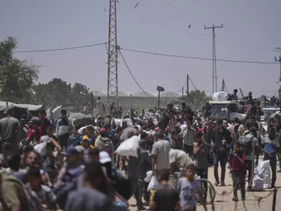 Palestinians carry bags containing food and humanitarian aid packages delivered by the Gaza Humanitarian Foundation, a U.S.-backed organization, in Rafah, southern Gaza Strip, Monday, June 16, 2025. (AP Photo/Abdel Kareem Hana)