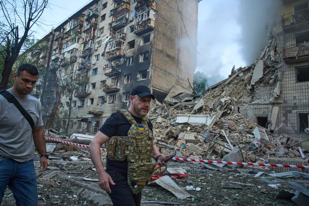 Ukraine's Interior Minister Ihor Klymenko, right, examines the site of a missile strike that ruined a residential building during Russia's massive missile and drone air attack in Kyiv, Ukraine, Tuesday, June 17, 2025. (AP Photo/Efrem Lukatsky)