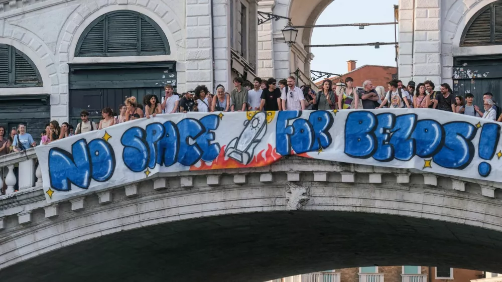 Protesters display a banner reading "No Space for Bezos!" on the Rialto Bridge during a protest against Amazon founder Jeff Bezos' upcoming wedding to Lauren Sanchez being held in Venice, Italy, June 13, 2025. REUTERS/Manuel Silvestri