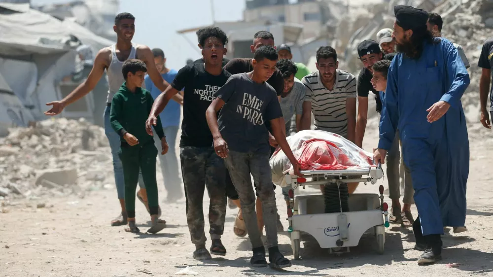 Mourners wheel a body on a medical bed, during the funeral of Palestinians killed by Israeli fire yesterday, while they sought aid in northern Gaza, according to Gaza's health ministry, outside Al-Shifa Hospital, in Gaza City, June 19, 2025. REUTERS/Mahmoud Issa   TPX IMAGES OF THE DAY