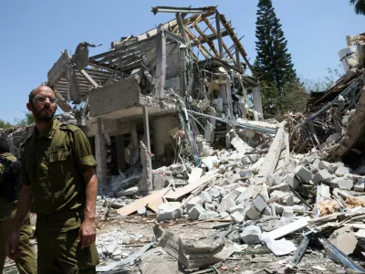 Members of Israeli forces work at an impact site following a missile attack from Iran on Israel, amid the Iran-Israel conflict, in Tel Aviv, Israel, June 22, 2025. REUTERS/Violeta Santos Moura