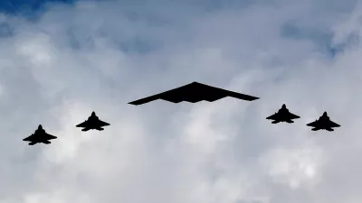 A U.S. Air Force B-2 Spirit Stealth Bomber (C) is flanked by four F-22 Raptor fighter planes during a flyover of military aircraft down the Hudson River and New York Harbor past York City, and New Jersey, U.S. July 4, 2020. REUTERS/Mike Segar REFILE - CORRECTING AIRCRAFT FROM "U.S. MARINE CORPS F-35 FIGHTERS" TO "F-22 RAPTOR FIGHTER PLANES".