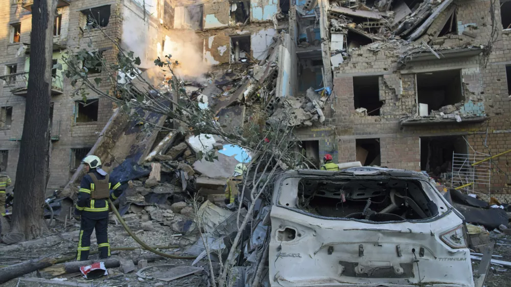 Firefighters work in a destroyed apartment building after a Russian attack in Kyiv, Ukraine, early Monday, June 23, 2025. (AP Photo/Efrem Lukatsky)