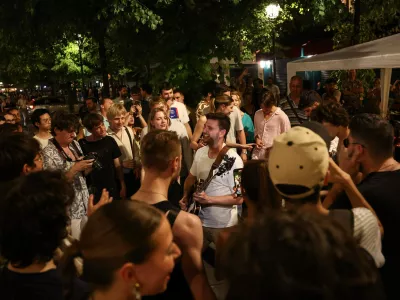 21 June 2025, France, Paris: Music enthusiasts listen to a man playing the guitar during the annual French street music festival "Fete de la Musique" in the 4th arrondissement of Paris. Photo: Romain Perrocheau/AFP/dpa