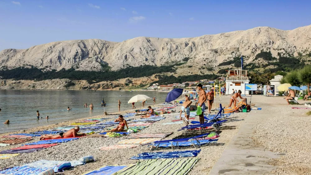 Baska, Krk, Croatia - July 6, 2012: People with their beach towels on the 1,800-meter-long Ba&scaron;ka beach (the Vela plaža, or "Great Beach") in this resort located on the SE of the Island of Krk. / Foto: Csfotoimages