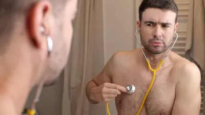 A cute man in his forties is listening to his own heartbeat. He is shirtless and looks gorgeous. / Foto: Ajr_images