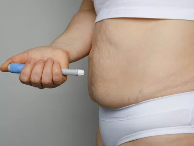 Weight Loss concept. Woman with Semaglutide Injection Pen and her Stomach closeup indoor / Foto: Jnemchinova