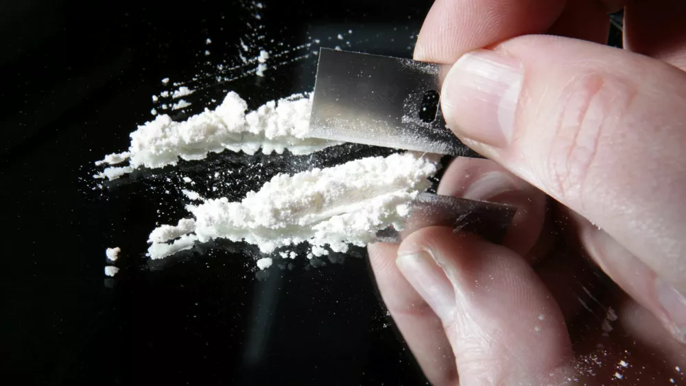 cocaine or other drugs cut with razor blade on mirror. hand dividing white powder narcotic / Foto: Tlnors