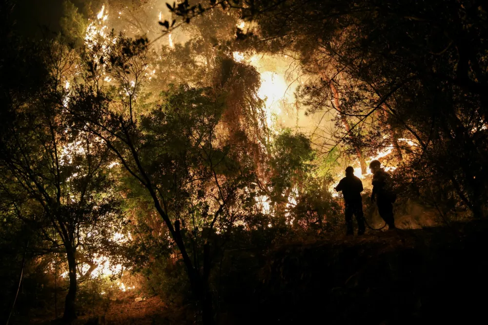 Firefighters try to tackle a wildfire burning on Chios island, Greece, June 23, 2025. REUTERS/Konstantinos Anagnostou   TPX IMAGES OF THE DAY