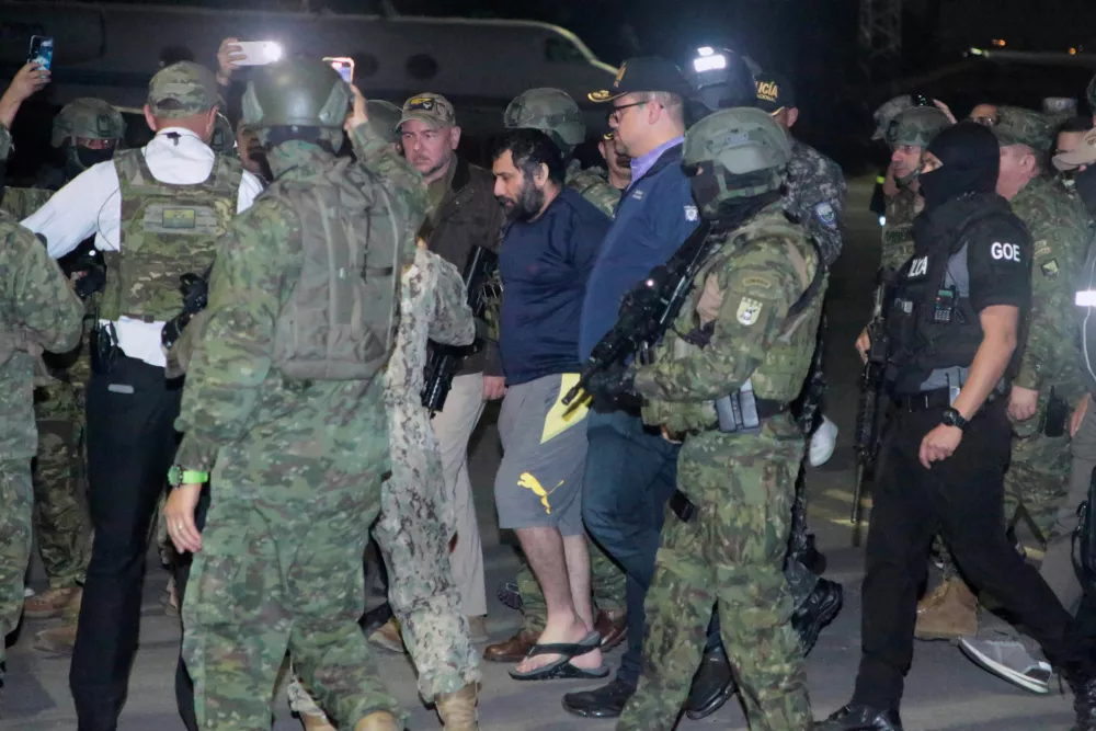 Escorted by soldiers and police officers, Adolfo "Fito" Macias, the leader of the Choneros gang, arrives in Guayaquil, Ecuador, after getting detained, Wednesday, June 25, 2025. (AP Photo/Joffre Flores)