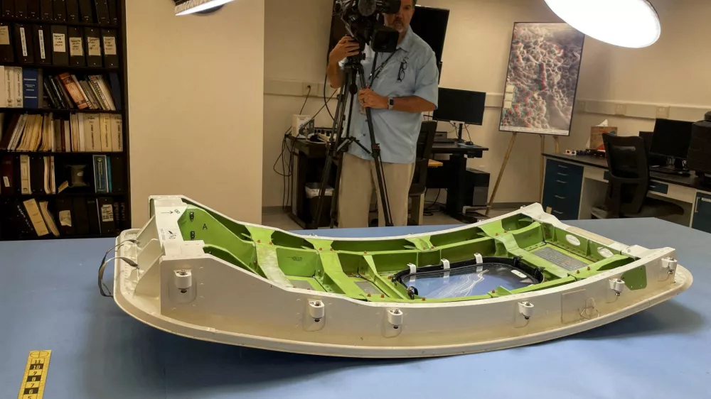 FILE PHOTO: A member of the news media views the Alaska Airlines Flight 1282 door plug in advance of National Transportation Safety Board hearings in early August on the January Alaska Airlines Boeing 737 MAX 9 in-flight door plug emergency, at the NTSB materials lab in Washington, U.S., July 30, 2024. REUTERS/David Shepardson/File Photo