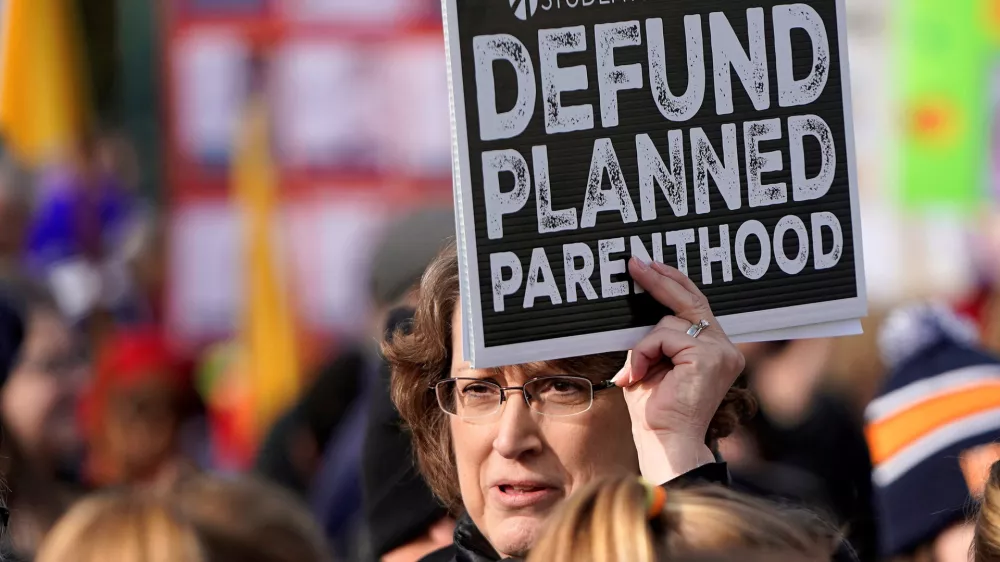 FILE PHOTO: An anti-abortion marcher carries a sign calling for the organisation Planned Parenthood to loose funding, during in the 46th annual March for Life at the Supreme Court in Washington, U.S., January 18, 2019. REUTERS/Joshua Roberts/File Photo
