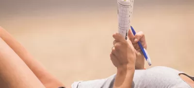 beautiful woman close up on body relaxed and have nice time doing a words play on paper. beach vacation leisure activity under the sunlight. skin tanner concept in holiday outdoor activity for lady / Foto: Simonapilolla