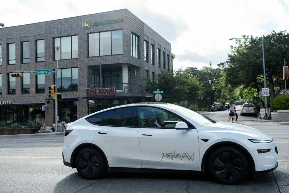 FILE PHOTO: A Tesla robotaxi drives on the street along South Congress Avenue in Austin, Texas, U.S., June 22, 2025. REUTERS/Joel Angel Juarez/File Photo