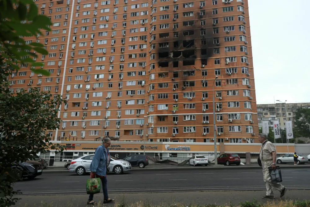 Residents walk in front of an apartment building hit by a Russian drone strike, amid Russia's attack on Ukraine, in Odesa, Ukraine June 28, 2025. REUTERS/Nina Liashonok