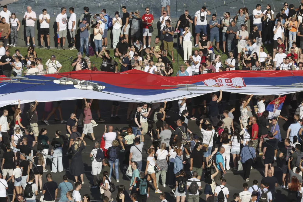 People attend a major anti-government rally to press their demand for an early election after nearly eight months of almost daily anti-corruption demonstrations that have shaken the populist government of President Aleksandar Vucic, in Belgrade, Serbia, Saturday, June 28, 2025. (AP Photo/Marko Drobnjakovic)