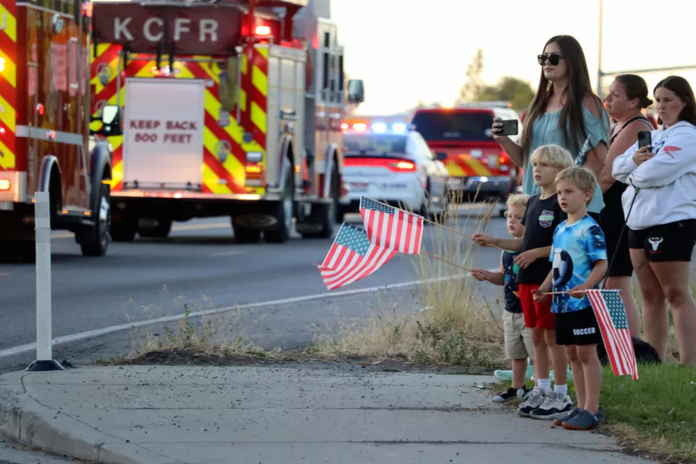 A procession from Kootenai Health headed to Spokane after a few firefighters were killed Sunday, June 29, 2025, when they were ambushed by sniper fire while responding to a blaze in a northern Idaho mountain community, in Coeur d'Alene, Idaho. (Bill Buley/Coeur D'Alene Press via AP)