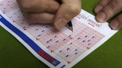 A man fills in a lottery ticket at a Lotto receiving office in Dortmund October 6, 2006. This Saturday the German public lottery 'Lotto' will distribute a total of around 35 million euros, which is the highest lottery jackpot in Germnay since the start of Lotto in 1955.    REUTERS/Ina Fassbender (GERMANY)
