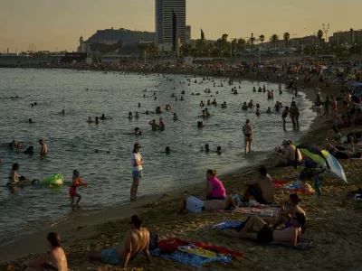 Swimmers cool off in the water at a beach on a hot day in Barcelona, Spain, Sunday, June 29, 2025. (AP Photo/Emilio Morenatti)
