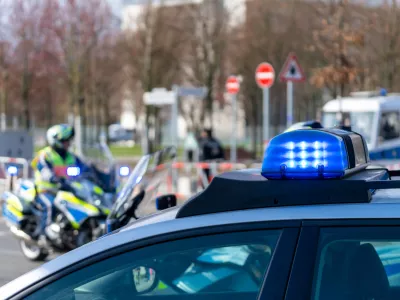 Blue Flash Light Of Police Car Against Police Officers On Motor Bike / Foto: Reinhard Krull
