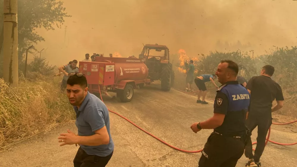 Firefighters and local residents respond to a wildfire in Menderes district of the Aegean city of Izmir, Turkey, June 29, 2025. Ihlas News Agency (IHA) via REUTERS ATTENTION EDITORS - THIS PICTURE WAS PROVIDED BY A THIRD PARTY. NO RESALES. NO ARCHIVES. TURKEY OUT. NO COMMERCIAL OR EDITORIAL SALES IN TURKEY.