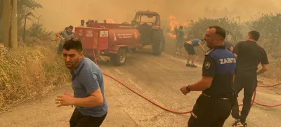 Firefighters and local residents respond to a wildfire in Menderes district of the Aegean city of Izmir, Turkey, June 29, 2025. Ihlas News Agency (IHA) via REUTERS ATTENTION EDITORS - THIS PICTURE WAS PROVIDED BY A THIRD PARTY. NO RESALES. NO ARCHIVES. TURKEY OUT. NO COMMERCIAL OR EDITORIAL SALES IN TURKEY.