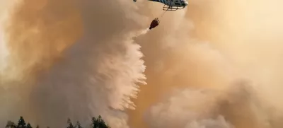 A firefighting helicopter drops its load of water on a forest fire near Santa Comba Dao, northern Portugal, Thursday, Aug. 11 2016. Firefighters in Portugal are battling multiple blazes fed by brush in a hot, dry summer for a sixth straight day. Major fires have also been raging in northwestern Spain and southern France. (AP Photo/Sergio Azenha)