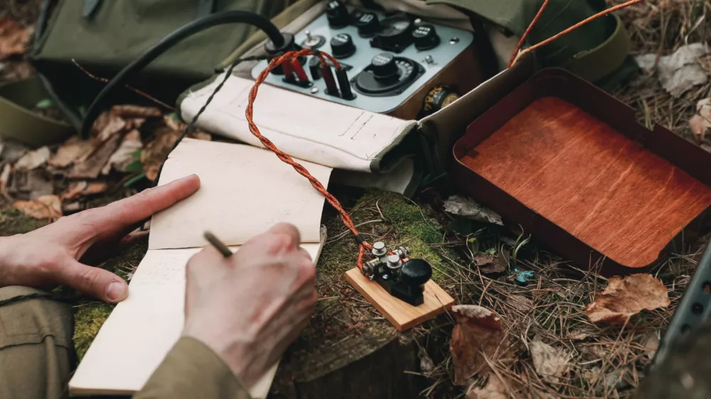 Russian Soviet Infantry Red Army Soldier In World War II using Russian Soviet Portable Radio Transceiver In Trench Entrenchment In Spring Autumn Forest.. Headphones And Telegraph Key. Close Up Hands, / Foto: Bruev