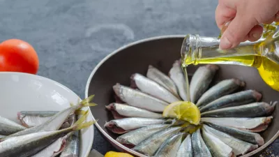 Woman is pouring olive oil into the pan. / Foto: Nkeskin