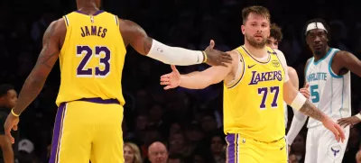 Feb 19, 2025; Los Angeles, California, USA; Los Angeles Lakers forward LeBron James (23) and guard Luka Doncic (77) celebrate after a play during the third quarter against the Charlotte Hornets at Crypto.com Arena. Mandatory Credit: Jason Parkhurst-Imagn Images