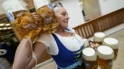 A waitress carryies beer mugs in the Hofbraeuhaus beer tent, on day one of the 189th 'Oktoberfest' beer festival in Munich, Germany, Saturday, Sept. 21, 2024. (AP Photo/Matthias Schrader)