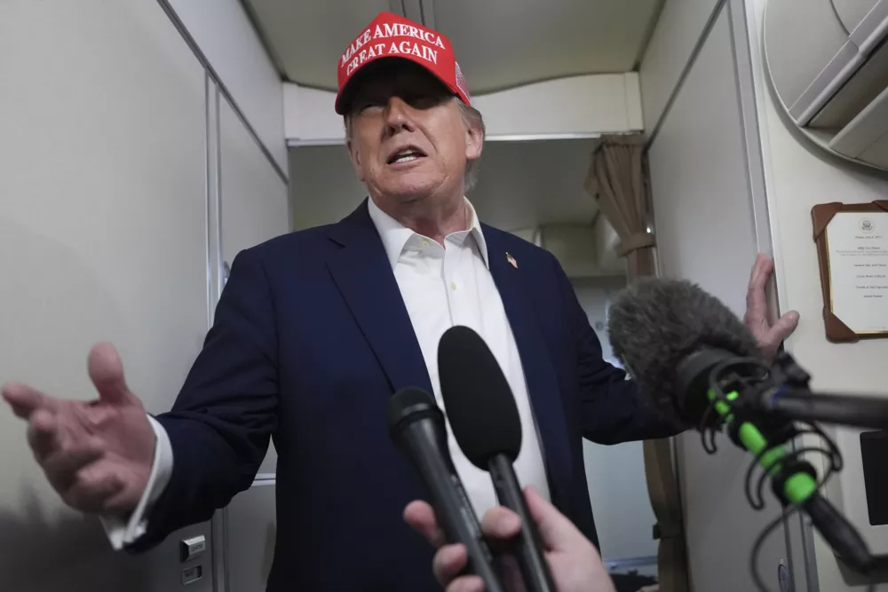 President Donald Trump speaks to reporters on board Air Force One, en route from Joint Base Andrews, Md., to Morristown Municipal Airport in Morristown, N.J., Friday, July 4, 2025. (AP Photo/Jacquelyn Martin)