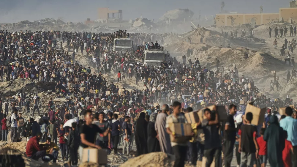 Palestinians carry sacks and boxes of food and humanitarian aid, unloaded from a World Food Program convoy that was heading to Gaza City in the northern Gaza Strip, Monday, June 16, 2025. (AP Photo/Jehad Alshrafi)