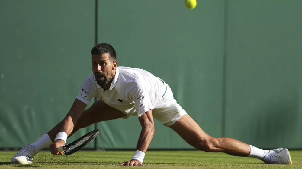 Serbia's Novak Djokovic returns to Italy's Flavio Cobolli during a quarterfinal men's singles match at the Wimbledon Tennis Championships in London, Wednesday, July 9, 2025. (AP Photo/Kin Cheung)