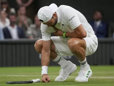 Bulgaria's Grigor Dimitrov clutches his chest with an injury which forced him to retire injured from a fourth round men's singles match against Italy's Jannik Sinner at the Wimbledon Tennis Championships in London, Monday, July 7, 2025. (AP Photo/Kin Cheung)