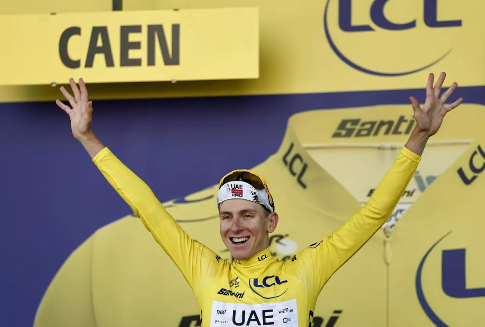 Cycling - Tour de France - Stage 5 - Caen to Caen - Caen, France - July 9, 2025 UAE Team Emirates XRG's Tadej Pogacar celebrates on the podium wearing the yellow jersey after stage 5 REUTERS/Benoit Tessier