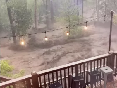 In this image taken from video, flash flooding is seen behind a house in Ruidoso, N.M., Tuesday, July 8, 2025. (Kaitlyn Carpenter via AP)