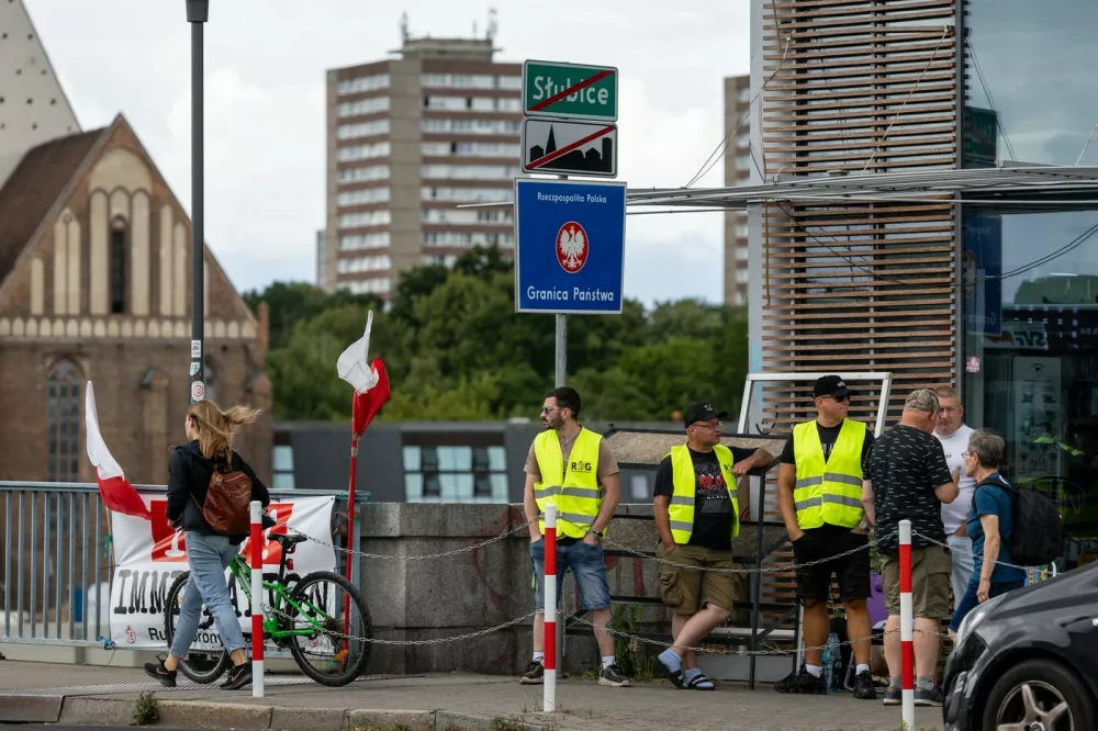 A girl (L) passes by a group of members of a far-right movement 'Border Defense Movement' (ROG) holding a post as a unofficial "citizens' patrol" at the Polish-German border in Slubice, western Poland, close to the German city of Frankfurt an der Oder, on July 7, 2025, as Poland temporarily reintroduced border controls with Germany and Lithuania, saying they are needed to control "illegal immigration". In total, 52 checkpoints have been set up on the border with Germany and 13 with Lithuania, the Polish interior minister said. The controls will last from 7 July to 5 August 2025 but could be extended. They will mostly consist of spot inspections, particularly of vehicles carrying several people, Polish officials said.,Image: 1019329709, License: Rights-managed, Restrictions:, Model Release: noFoto: Profimedia